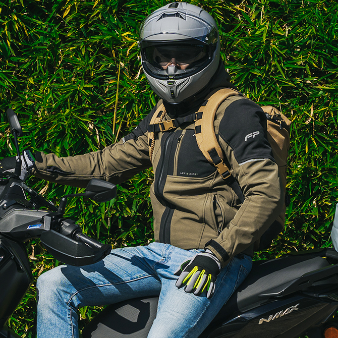 piloto sobre su moto con guantes de moto deportivos en color negro con gris y neón