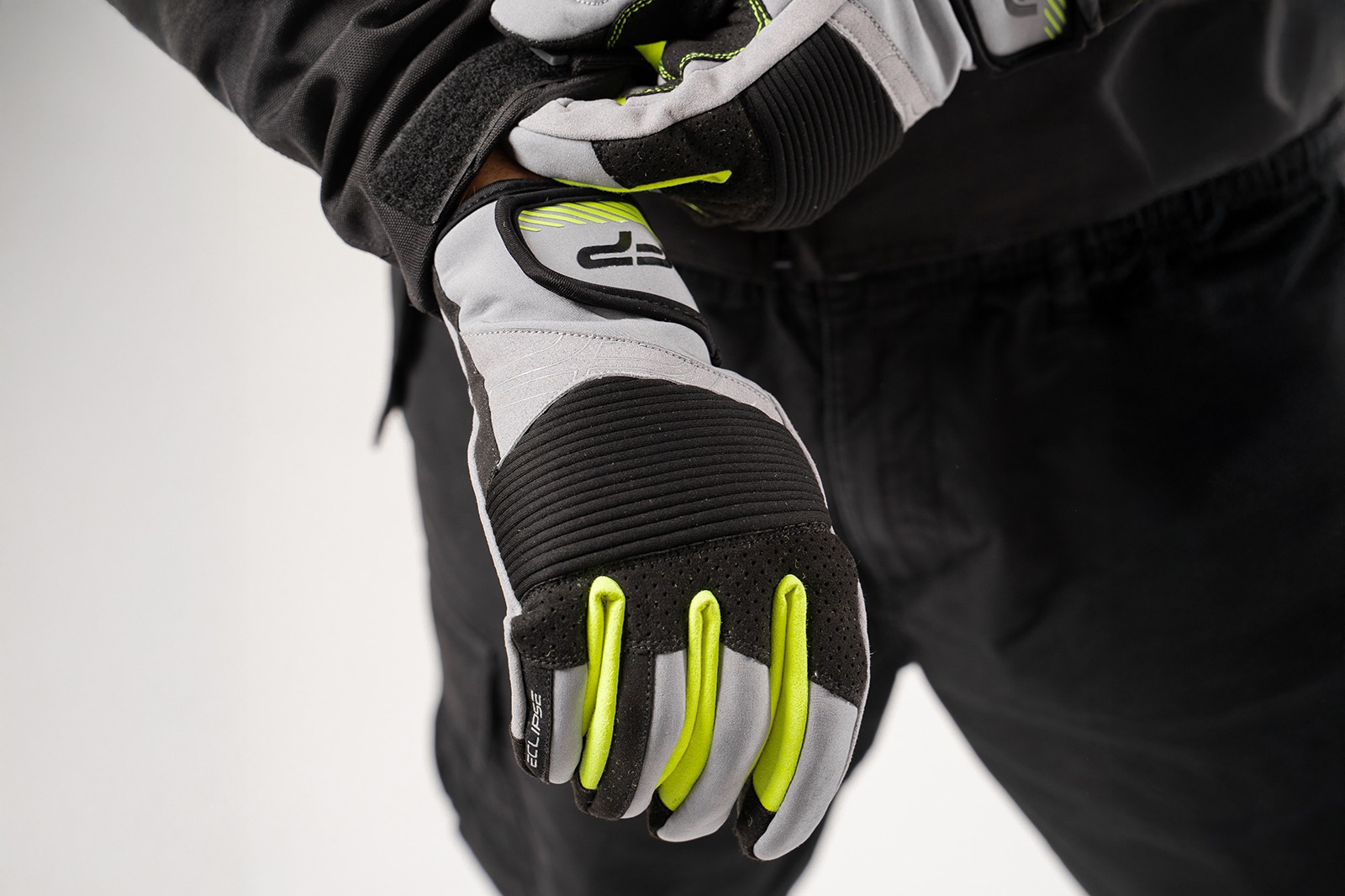 piloto con los guantes de moto deportivos en color negro con gris y neón puestos