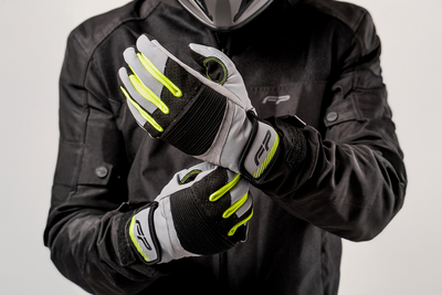 Piloto con guantes de moto deportivos en color negro con gris y neón