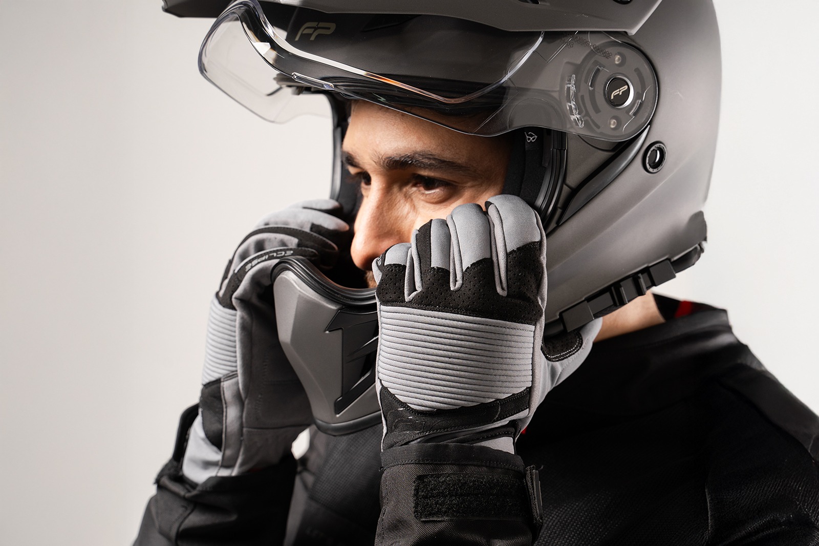 motociclista poniendose casco con Guantes de proteccion para moto FP Eclipse grises