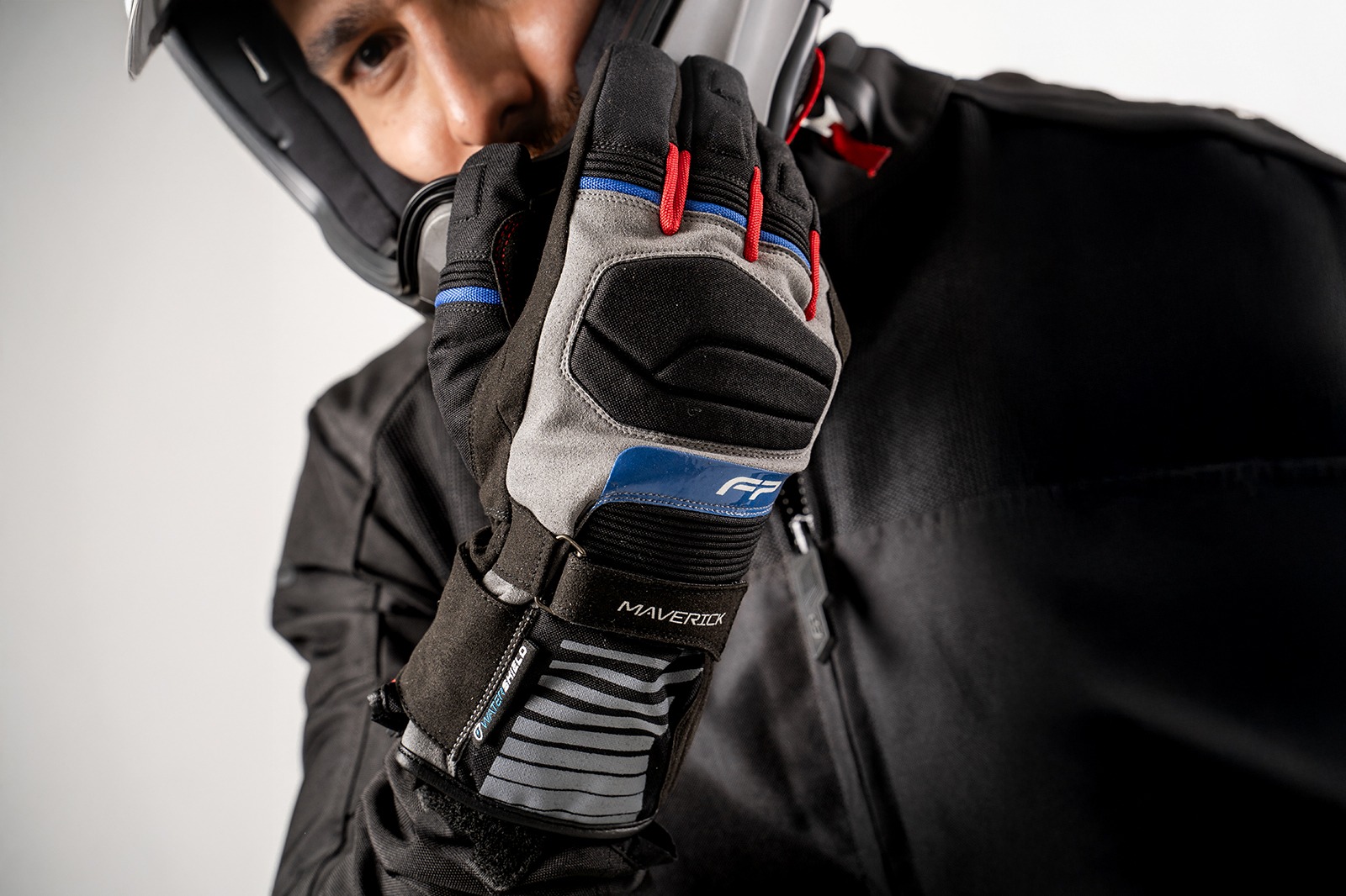 Motociclista usando guantes Maverick Gris impermeables, ideales para rutas largas en climas cambiantes