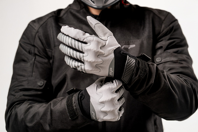 Motociclista hombre usando guantes Ultralight grises para moto, extra delgados y ventilados, ideales para aventura y enduro