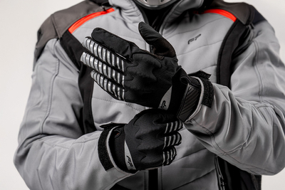 Motociclista hombre usando guantes Ultralight negros, guantes de aventura off-road extra delgados, ligeros y ventilados