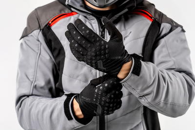 hombre con chaqueta y guantes de motocross