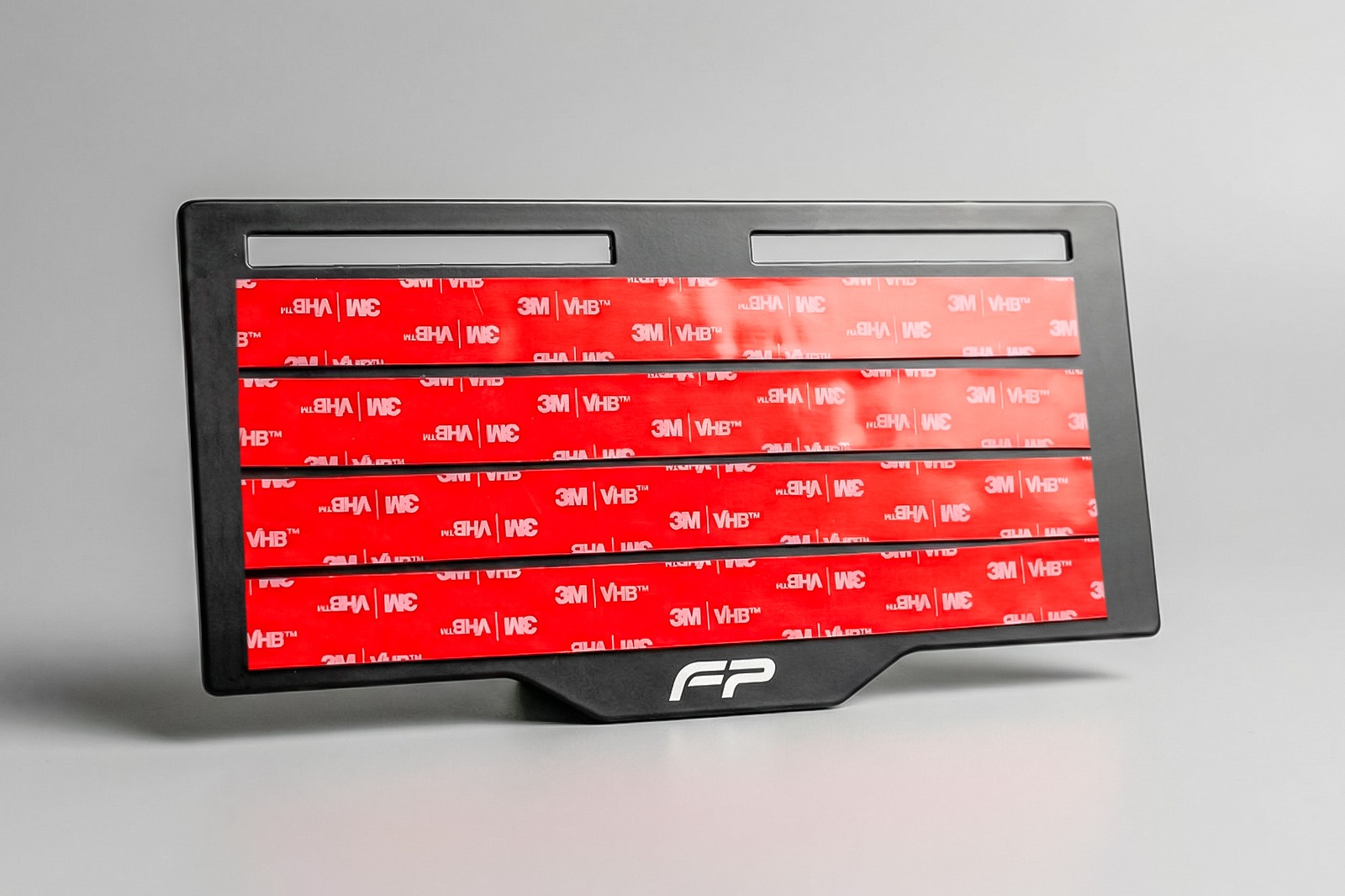 Detalle del soporte de matrícula FP con acabado negro.