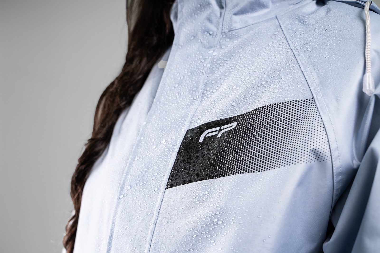 Detalle reflectivo en chaqueta impermeable de mujer azul