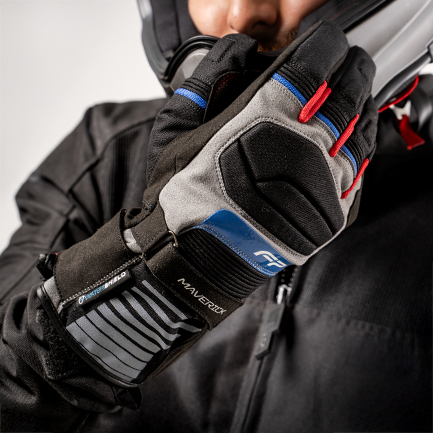 Motociclista usando guantes Maverick Gris impermeables, ideales para rutas largas en climas cambiantes.