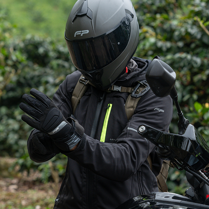 Motociclista usando guantes Maverick Negro impermeables, combinaci&oacute;n de estilo y protecci&oacute;n para touring