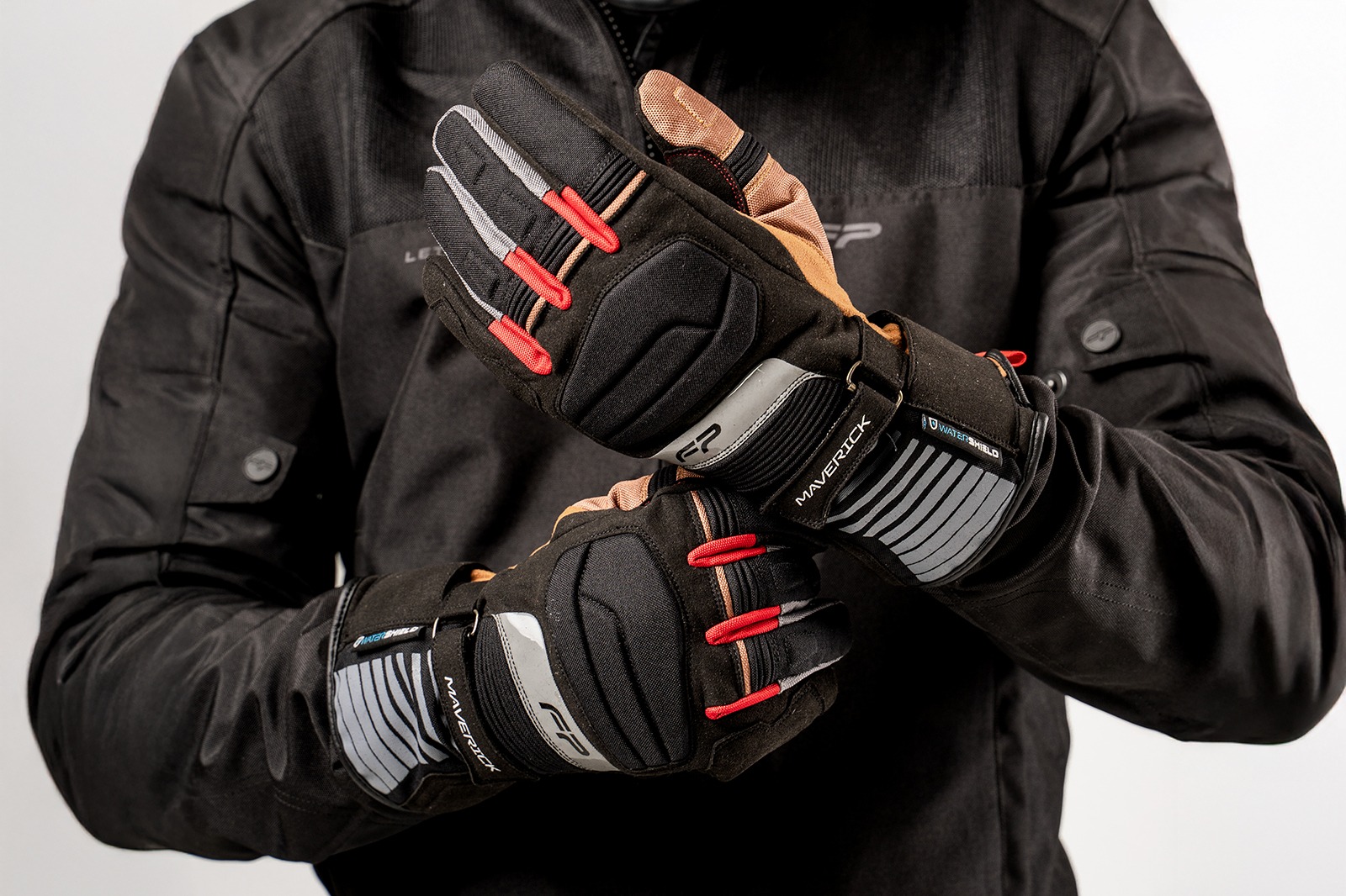 Motociclista ajustando guantes impermeables Maverick Tobacco con membrana Hipora® y diseño clásico para turismo en moto