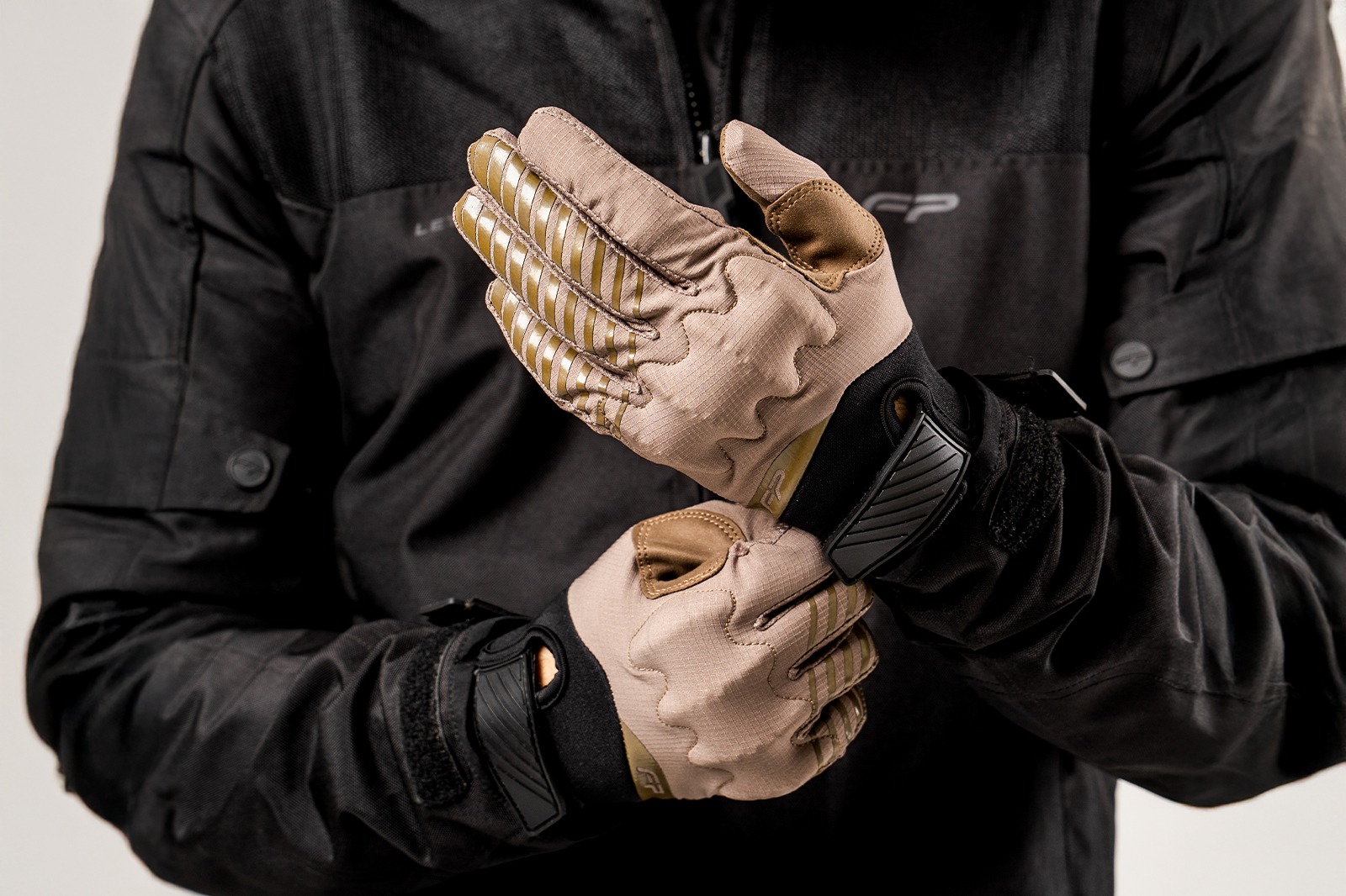 Motociclista hombre usando guantes Ultralight Desert color arena, ultraligeros y ventilados para aventura off‑road