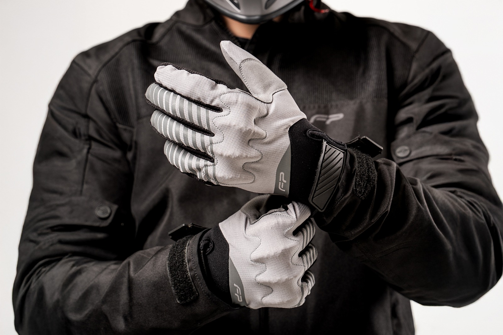 Motociclista hombre usando guantes Ultralight grises para moto, extra delgados y ventilados, ideales para aventura y enduro