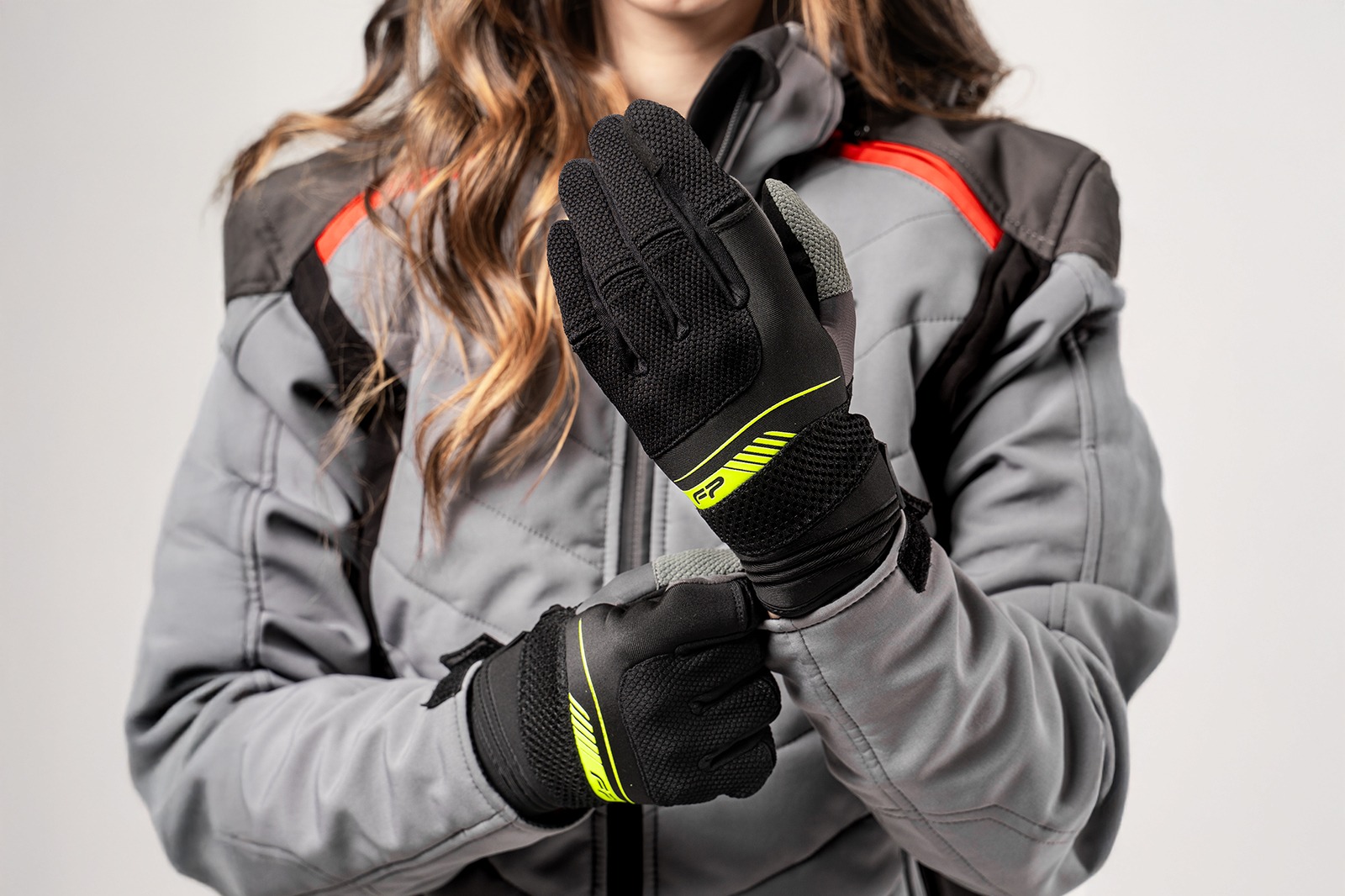 Motociclista dama usando guantes Verona Neon, diseño vibrante con ajuste entallado y ventilación para mayor comodidad